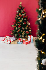 red decor garland Christmas tree with gifts for the new year interior
