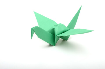 green paper origami bird on a white