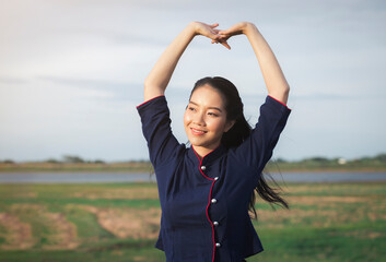 Happy smiling Asian beautiful woman sitting on a wooden bridge outdoors, countryside