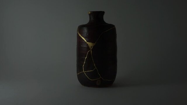 Kintsugi bizen sake bottle. Bright gold cracks lighted up. Fragile cracks trauma representation. Psycology.