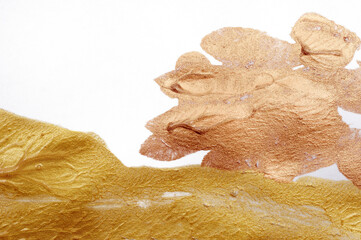 Abstract background painted with a brush of gold and bronze paint with place for text on a white...