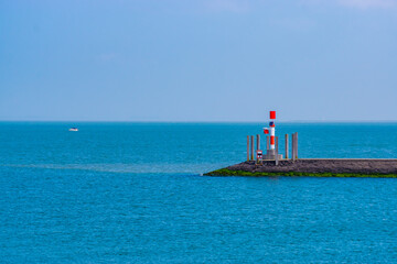pier with small lighthouse and blue ocean, scenery of the harbor of Breskens, Zeeland, The Netherlands