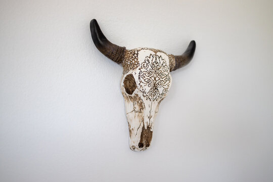 Southwestern Decorative Cow Skull Head Hanging on a White Bedroom Wall in a Desert Bedroom