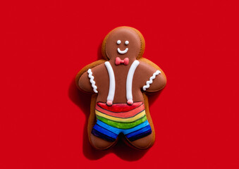 Lgbt pride. Red conceptual background. Diversity tolerance. Individuality freedom. Happy African gay gingerbread man in rainbow shorts isolated on bright copy space.