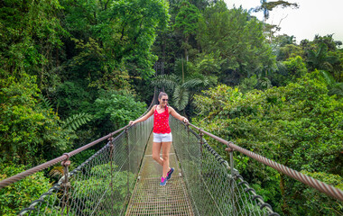 Arenal Hanging Bridges, young woman hiking in green tropical jungle, Costa Rica, Central America.