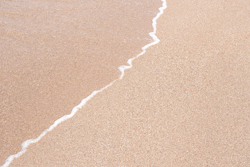 Soft beautiful sea wave on sandy beach. Background texture