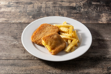 San Jacobo steak filled with cheese and ham on wooden table