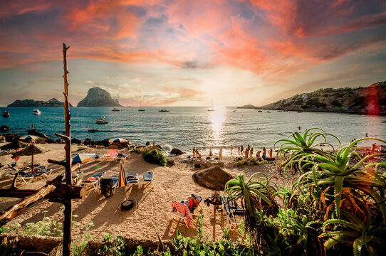 Picturesque View Of Cala D'Hort Tropical Beach, People Hangout In Beautiful Beach With Es Vedra Rock View During Magnificent Vibrant Sunset Glowing Sun. Balearic Islands. Ibiza, Spain