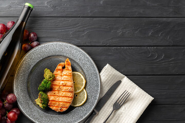 Grilled salmon steak with broccoli on grey plate