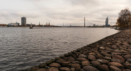 Fototapeta premium View of the city from the rocky shore, you can see the pier and the suspension bridge