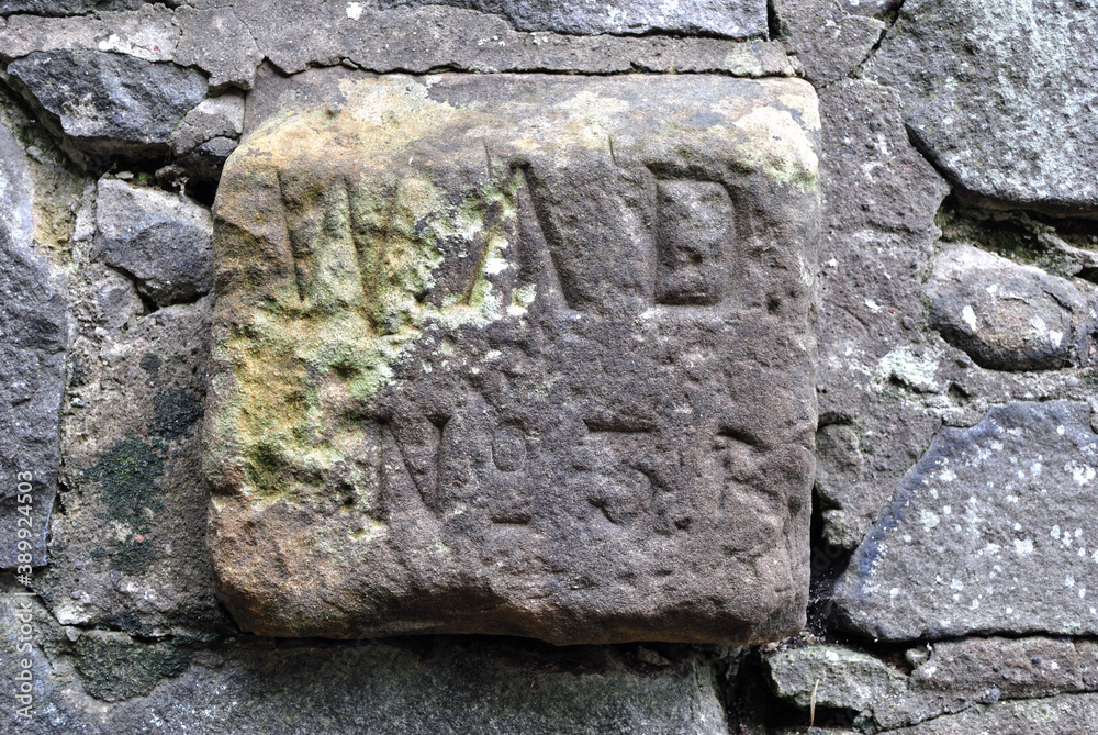 Wall mural Close Up of Old Weathered Stone Marker Plaque on Exterior Wall 'WD  No 4' and Small Arrow 