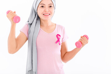 Asian women muslim religious women in hijab attach a pink ribbon to their tops. Doing exercise by lifting pink dumbbells.  breast cancer concept, cancer prevention concept. Acne and dark spots.