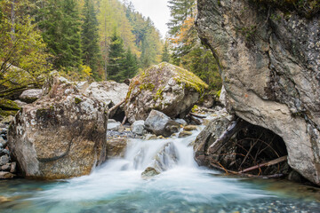 Naklejka na ściany i meble Flowing autumn waterfall in Chamonix in the French Alps