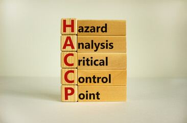 Wooden cubes and blocks with words 'HACCP, hazard analysis critical control point'. Beautiful white background, copy space. Business concept.
