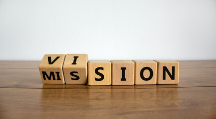 Turned wooden cubes and changed the word 'mission' to 'vision'. Beautiful wooden table, white background, copy space. Business concept. © Dzmitry