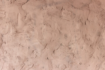 The surface of a rough uneven wall, plastered with fine marble chips.
