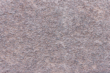 The surface of a rough uneven wall, plastered with fine marble chips.