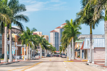 Fototapeta Fort Myers, USA - April 29, 2018: City town street during sunny day in Florida gulf of mexico coast for shopping and palm trees obraz