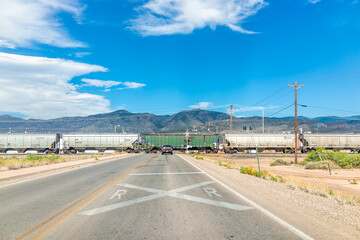 Alamogordo, USA - June 9, 2019: New Mexico city with train crossing on railroad with car waiting on...