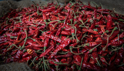 many red hot spice chili pepper  on a market in a big container, closeup 