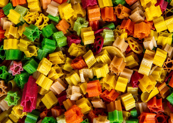 colorful pasta on a market in a big sack, natural colored in many different colors, yellow, green, red  and orange can be used as background or wallpaper 