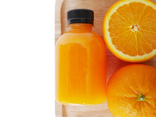 The orange juice and half of oranges on a cutting board