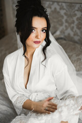 Portrait of beautiful bride with fashion veil at wedding morning