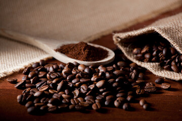coffee beans, and wooden spoon with ground coffee, raffia cloth bag, brown background