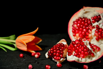 pomegranate with tulip on a black background