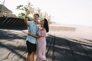 Joyful couple taking selfie on coast