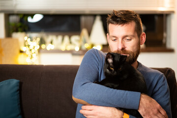 man with cat celebrating Christmas at home social distancing