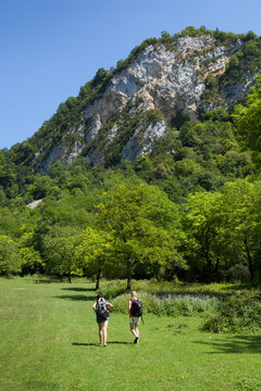 Vertical shot of two woman hikers hiking in the green nature of Cerdon, Ain, in Eastern France