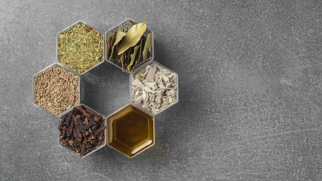 Spices in hexagonal jars on a stone surface. Stop motion animation