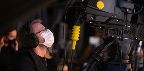 masked cameraman is filming a television show in the studio.