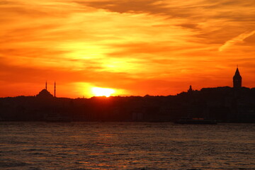 Naklejka premium Cityscape of Istanbul at sunset with dramatic orange clouds. Sunset in Istanbul. Istanbul background photo.