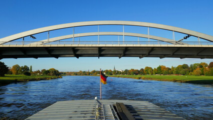 Schiff fährt unter der  Waldschlösschenbrücke auf der Elbe bei Dresden hindurch bei blauem Himmel