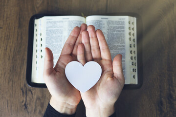 Hands female prayer to Load with broken heart in hands on the bible,Concept Pray for...