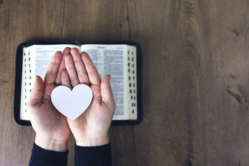 Hands female prayer to Load with broken heart in hands on the bible,Concept Pray for...
