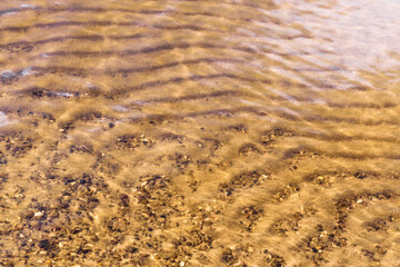 .river bank close up water sand stones