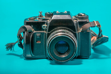 The frontal view of an old and dusty  camera on film with lens.