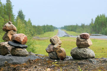 Fototapeta na wymiar round stone towers along the road and forest in nature