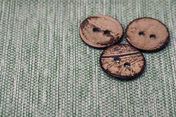Three large old buttons made of wood on canvas from my grandmother's box. Vintage items for creativity and needlework.