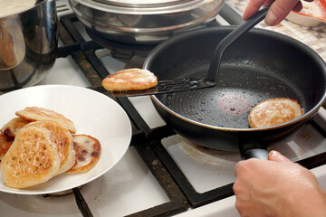 Baked pancakes are transferred from the pan to the plate with a spatula.
