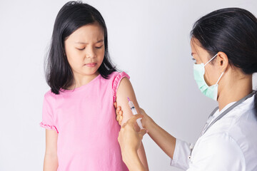 Doctor injecting vaccination in arm of asian little child girl, little asia girl receiving injection from doctor. healthy and medical concept.