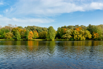 Fototapeta na wymiar Autumn landscape on the river. Trees by the river
