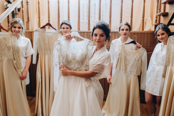 Fototapeta premium Cheerful, young, attractive witnesses next to the bride. Wedding preparations. Fitting dresses.
