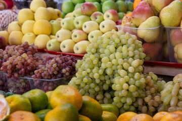 ripe grapes, tangerines, apples, pears and other fruits lie on market counter ready for sale. Vitamins for healthy nutrition. healthy lifestyle