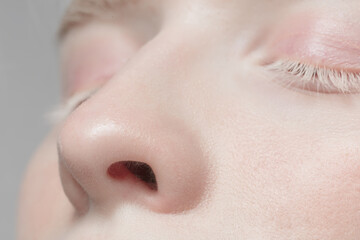 Nose and eyelid. Close up portrait of beautiful albino female model. Parts of face and body....