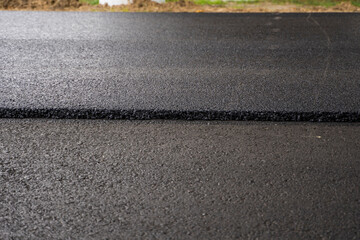 A large layer of fresh hot asphalt. Layer of asphalt raw material in a shallow depth of field....