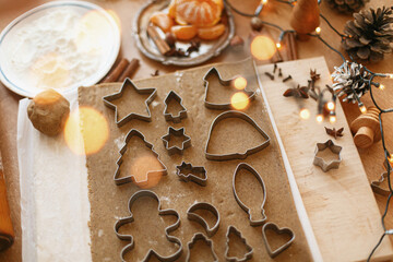 Raw gingerbread dough with metal cutters, festive decorations and lights. Christmas advent